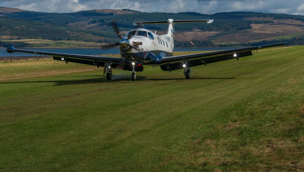 PC-12 aircraft landing on the grass
